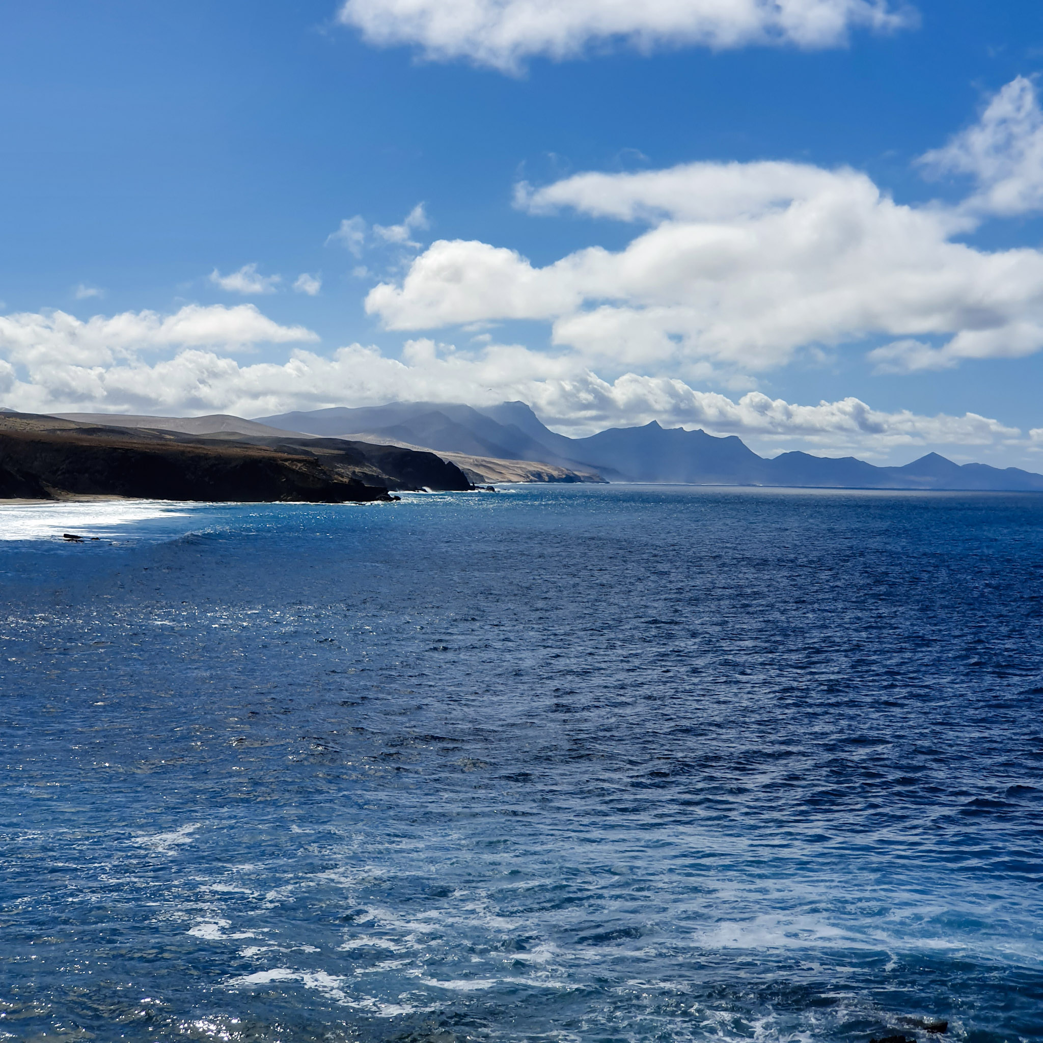 point-de-vue-sur-locean-et-une-chaine-de-montagne-pendant-une-journee-ensoleillee